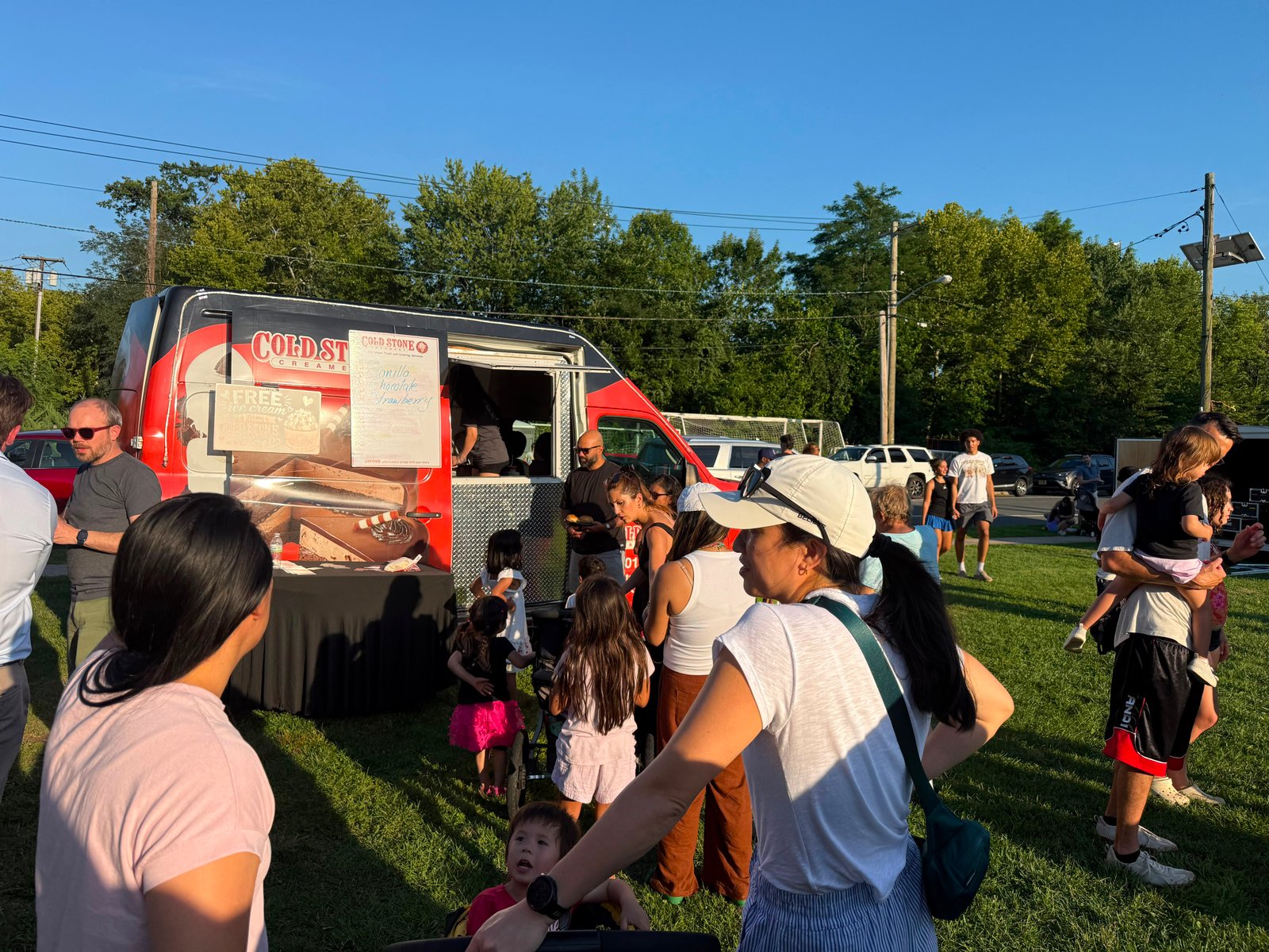 Cold Stone ice cream truck serving a crowd of guests, including children, at an outdoor event